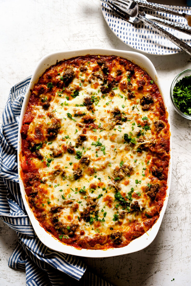 Beefy tortellini pasta bake with marinara, mozzarella, and golden cheese in a casserole dish
