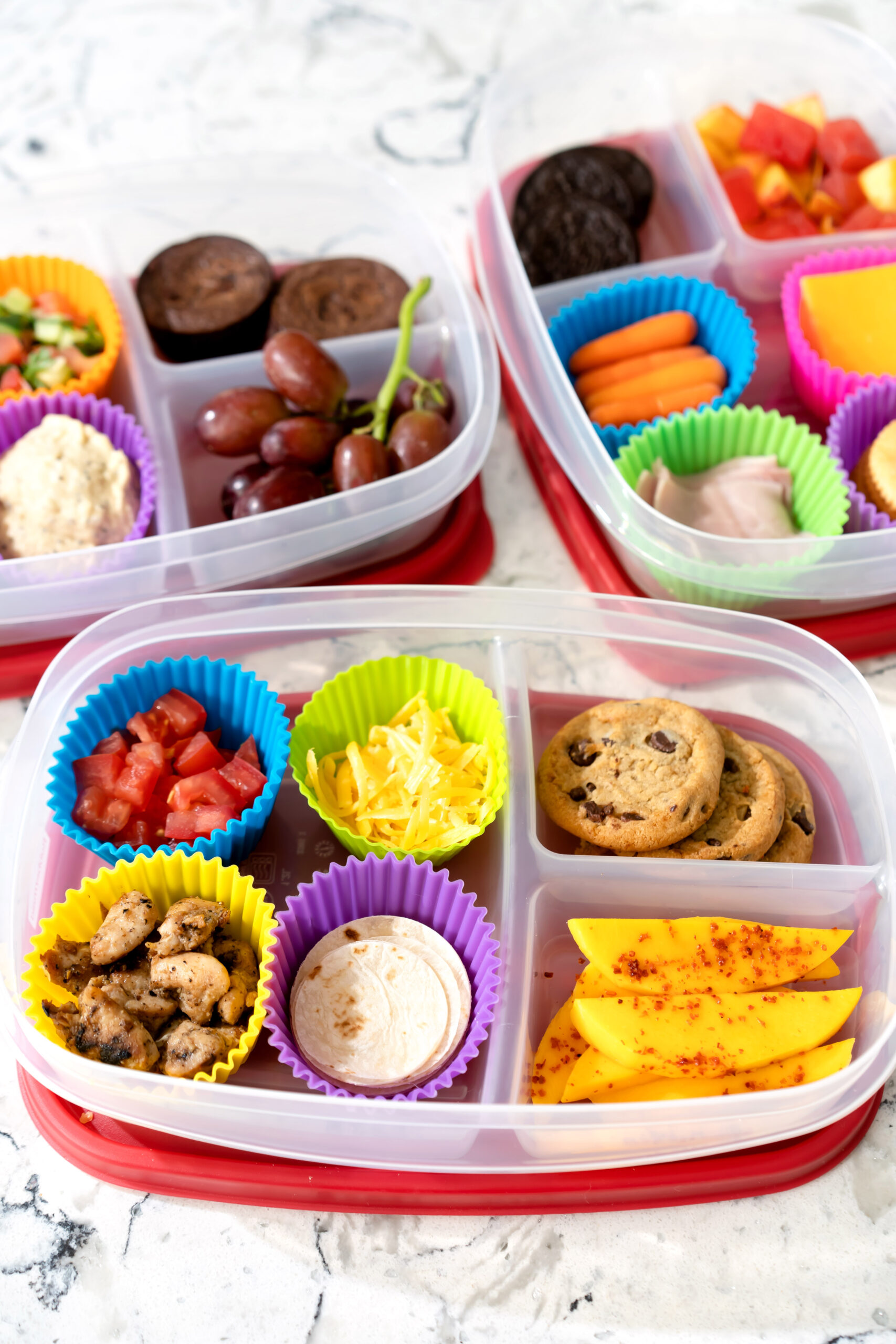 Divided meal prep container packed with turkey, cheese, crackers, fruit, and veggies.