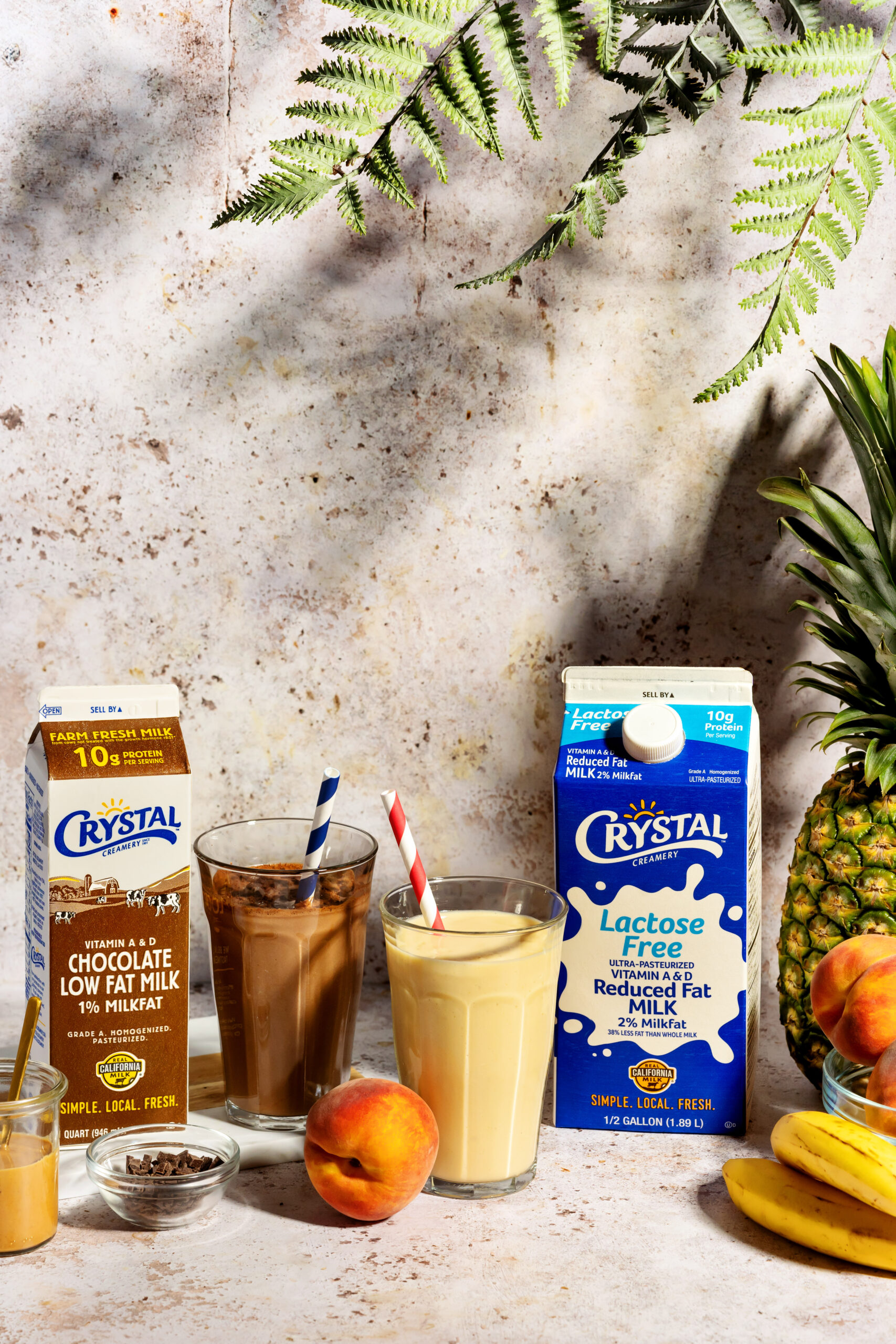 Smoothies in glass jars with straws on a wooden table