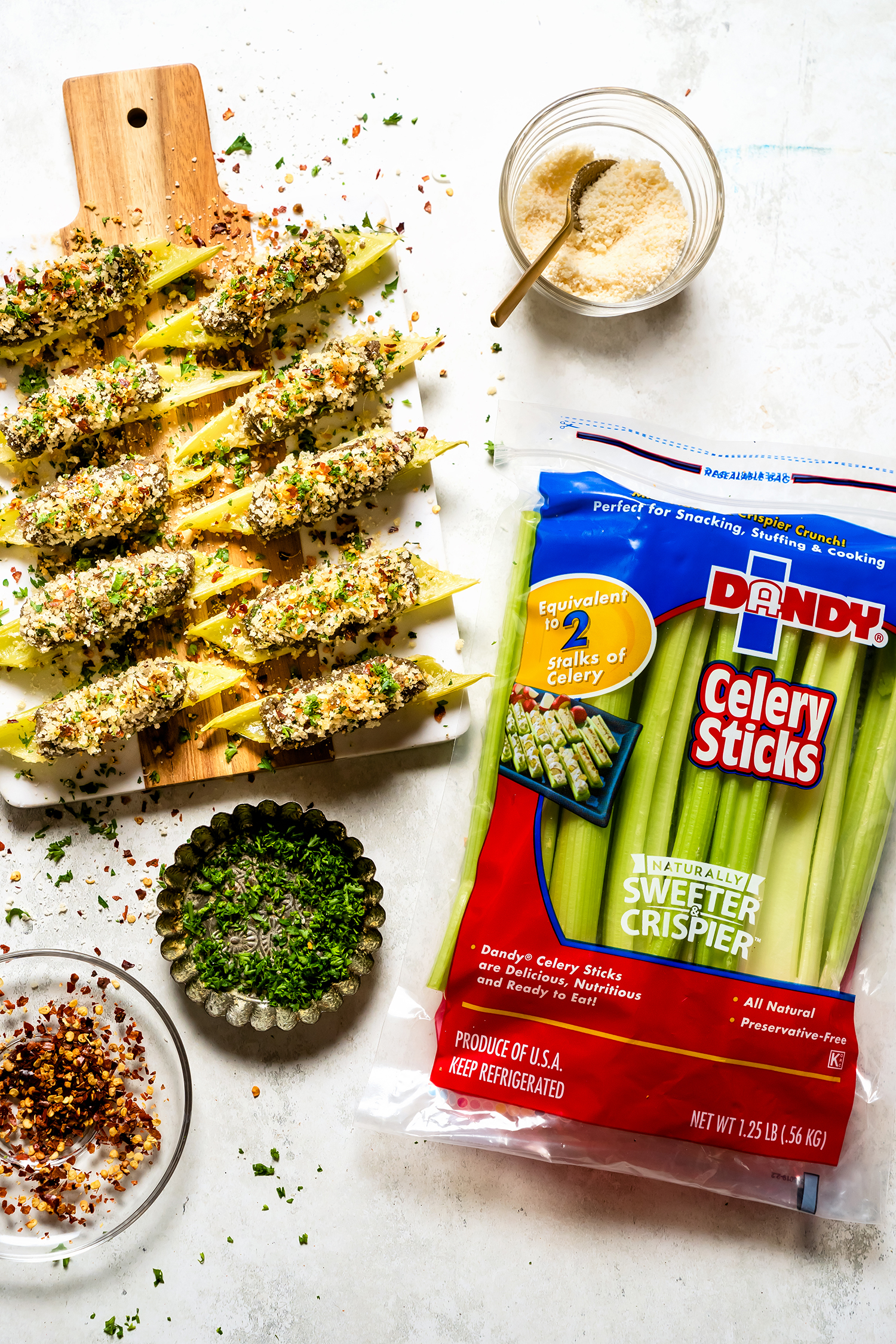 Celery boats filled with sausage and cheese on a white plate